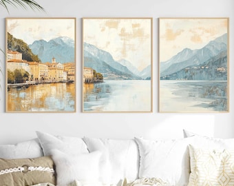 May include: A set of three abstract landscape paintings featuring a lake, mountains, and a small town. The paintings are in shades of blue, green, and gold.