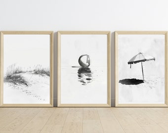 Puede incluir: Tres ilustraciones en blanco y negro enmarcadas de escenas de playa. La primera imagen muestra una playa con hierbas altas y dunas de arena. La segunda imagen muestra una pelota de playa flotando en el agua. La tercera imagen muestra una sombrilla de playa en la arena.