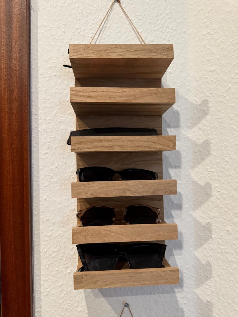 Personalisiertes Brillenregal aus Holz mit mehreren Sonnenbrillen, wandmontiert