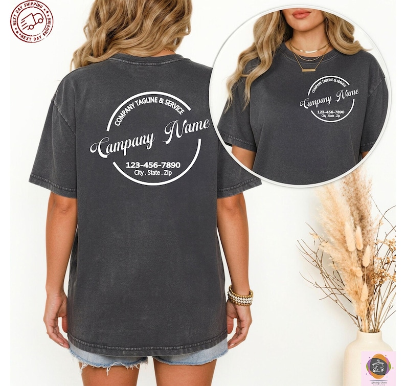 May include: Dark gray t-shirt with a circular design on the back that includes the text "Company Name", "Company Tagline & Service", and a phone number and address. The shirt is short-sleeved and has a relaxed fit.