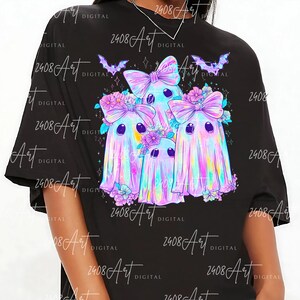 a black t-shirt with a colorful graphic design depicting three ghostly, bow-wearing figures surrounded by flowers and bats.