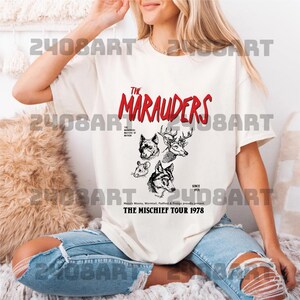 a woman sitting on a bed wearing a t - shirt