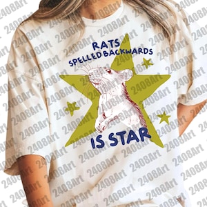 May include: White t-shirt featuring a rat illustration inside a green star. The text reads "RATS SPELLED BACKWARDS IS STAR" in blue and black. The design includes small yellow stars.