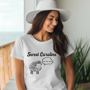 May include: White t-shirt with a black cartoon sheep and the text "Sweet Caroline" and "BA-BA-BAA" in a speech bubble.