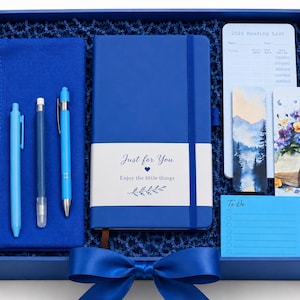 May include: A blue gift box containing a blue pencil case, three blue pens, a blue notebook with a white band reading Just for You Enjoy the little things, a 2026 Reading List card, two illustrated bookmarks, and a blue To Do notepad.