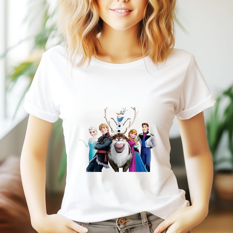 May include: White t-shirt with a colorful graphic print of characters from the animated movie Frozen. The characters include Elsa, Anna, Kristoff, Olaf, and Sven the reindeer.