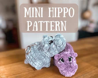 May include: Two crocheted mini hippopotamus toys, one gray and one purple, on a wooden surface. The text "MINI HIPPO PATTERN" is displayed above the toys. The text "PDF PATTERN" is displayed above the text "MINI HIPPO PATTERN". The text "@webb_thread" is displayed below the toys.
