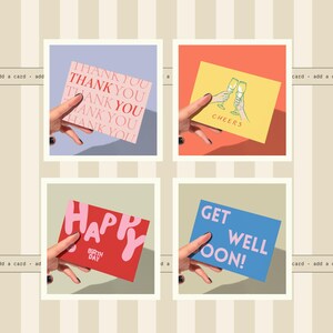 four different greeting cards being held by a hand, each with a unique design and message.