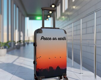 May include: Black suitcase with a sunset scene and the text "Peace on earth" printed on the front.