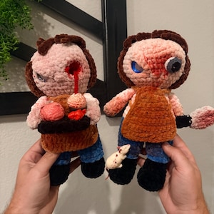 May include: Two plush dolls crafted from soft yarn, featuring brown hair, blue pants, and black boots. One doll has a red eye injury and holds a tray with red items. The other doll has a bloodied face, a brown apron, and holds a white rat figure.