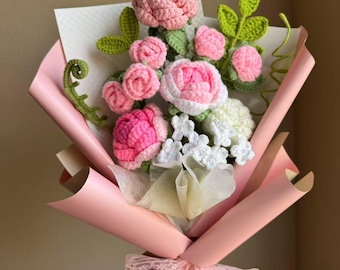 May include: A bouquet of crocheted flowers in pink and white, wrapped in pink tissue paper and tied with a pink lace ribbon.