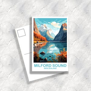 Op de afbeelding: Een ansichtkaart met een illustratie van Milford Sound, Nieuw-Zeeland. De afbeelding toont een meer dat de omliggende bergen weerspiegelt, met een blauwe lucht erboven. De tekst "MILFORD SOUND NEW ZEALAND" is lichtblauw.
