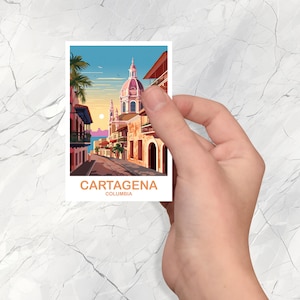 May include: A postcard with a photo of a street in Cartagena, Colombia. The street is lined with colorful buildings and a church with a pink dome. The text on the postcard reads 'Cartagena, Colombia'.