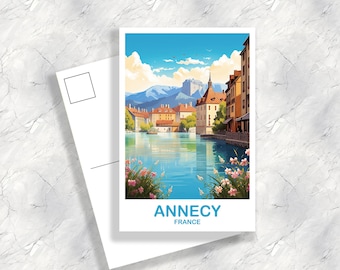 Puede incluir: Una postal con una ilustración colorida de la ciudad de Annecy, Francia. La postal muestra una vista del canal con edificios a lo largo de la orilla del agua. El texto "Annecy, Francia" está impreso en la parte inferior de la postal.