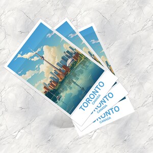Pu&ograve; includere: Tre cartoline impilate con un'illustrazione blu e bianca dello skyline di Toronto, inclusa la CN Tower, e il testo "TORONTO CANADA" su ogni cartolina.