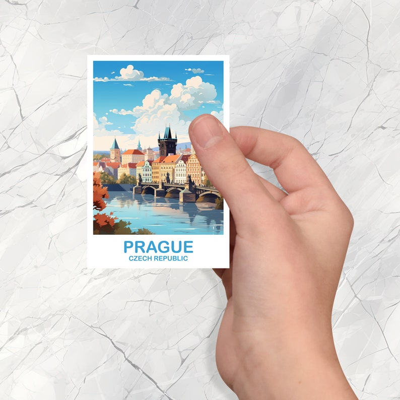 May include: A vintage-style postcard featuring a colorful illustration of Charles Bridge in Prague, Czech Republic. The postcard has a blue border and the text "Prague, Czech Republic" at the bottom.