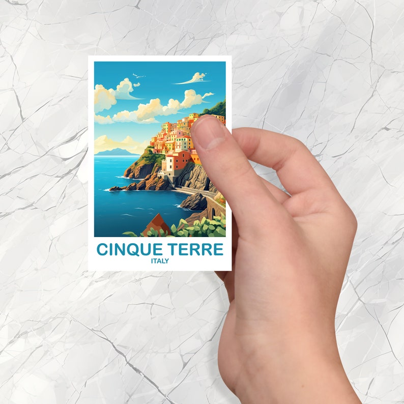 May include: A postcard featuring a colorful illustration of the Cinque Terre region in Italy. The postcard shows a picturesque coastal town with colorful buildings built into the hillside, overlooking a blue sea.
