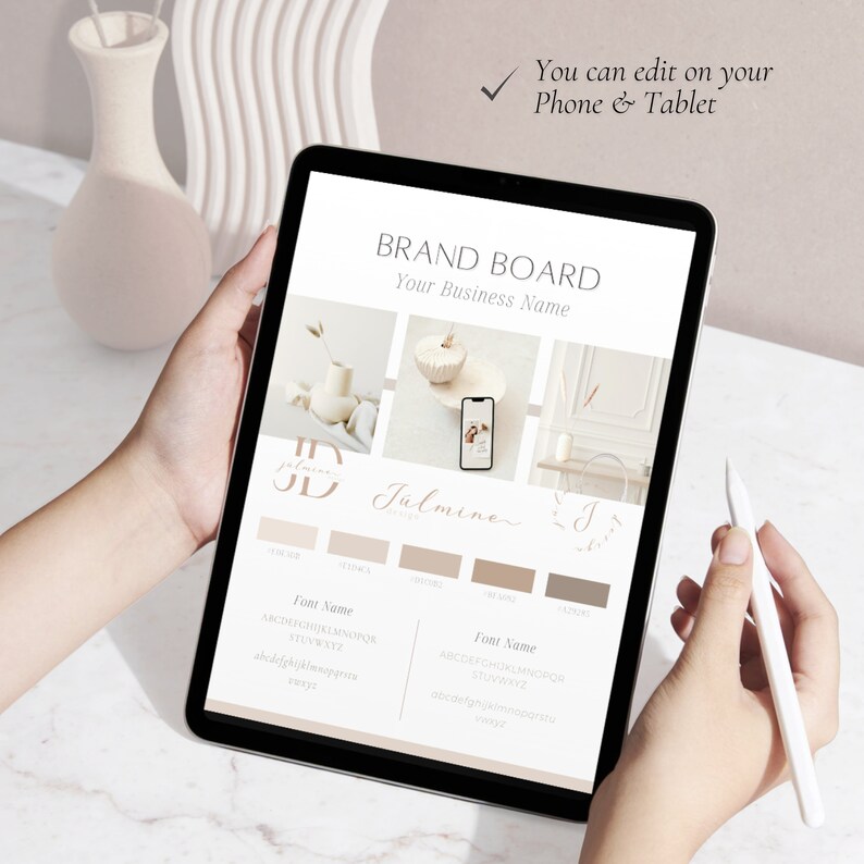 May include: A digital tablet screen displaying a brand board template with the text "BRAND BOARD" and "Your Business Name". The template includes a logo, color palette, and font choices. The text "Jalmine" is written in a cursive font. The tablet is being held by a person's hands.