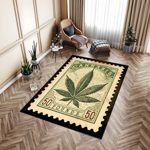 Puede incluir: Alfombra rectangular con un diseño de hoja de cannabis. La alfombra presenta una gran hoja de cannabis verde en el centro, sobre un fondo beige con texto tipo guion. La alfombra está enmarcada por un borde verde con la palabra "CANNABIS" y los números "50" y "POUNDS".