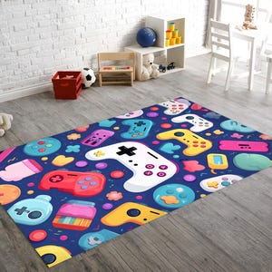 Peut inclure: Un tapis bleu avec un motif coloré de manettes de jeux vidéo, de cœurs et d'autres motifs amusants.