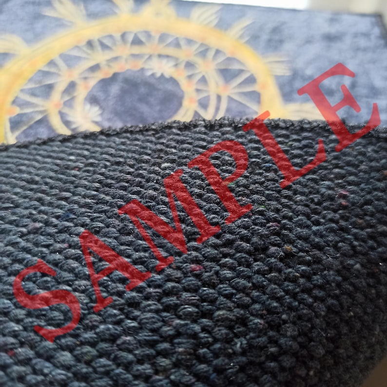 K&ouml;nnte beinhalten: Nahaufnahme eines dunkelblauen Stoffes mit einer strukturierten Oberfl&auml;che. Das Wort "SAMPLE" ist in roten Buchstaben auf dem Stoff gedruckt.