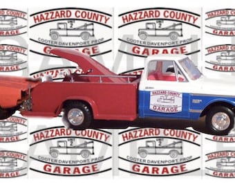 May include: A red and white tow truck with a blue stripe and the words "Hazzard County Garage" on the side. The truck is towing a red car.