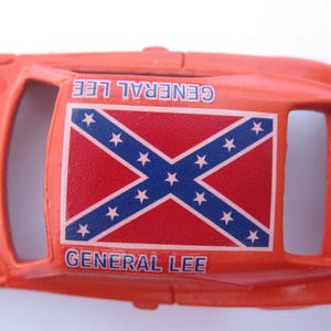 May include: Orange toy car with a Confederate flag on the roof and the words "General Lee" printed on the sides.