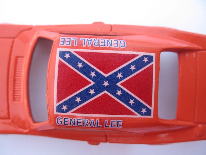 May include: Orange toy car with a Confederate flag on the roof and the words "General Lee" printed on the sides.