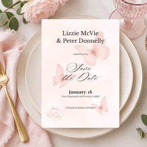 Può includere: Un biglietto d'invito rettangolare con uno sfondo acquerello rosa tenue. La carta presenta i nomi "Lizzie McVie & Peter Donnelly" e il testo "Save the Date" con la data "18 gennaio". Delicate illustrazioni di farfalle rosa adornano la carta.