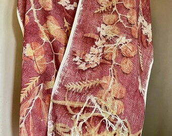 May include: A red silk scarf with a botanical print of leaves and branches in shades of brown and yellow.