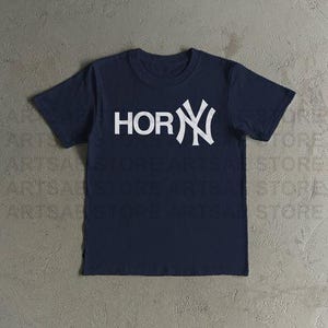 May include: A navy blue t-shirt featuring the word "HOR" and a white "NY" logo. The short-sleeved top is made of a soft material, suitable for casual wear.