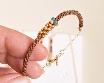 Macramé bracelet with natural apatite and gold-plated 925 silver from the Marea Collection. Handmade bracelet with chain and natural stones.