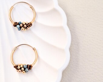 Gold-plated sterling silver hoop earrings from the Marea Collection. Gold hoops made of macramé and natural stones. Handmade jewelry.