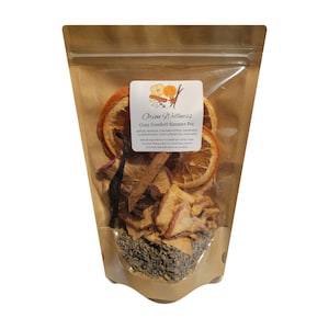 Può includere: Un sacchetto di carta marrone contenente un mix per pentola a fuoco lento con fette di arancia e mela essiccate, bastoncini di cannella, boccioli di lavanda e anice stellato. L'etichetta riporta Orion Wellness Cozy Comfort Simmer Pot.