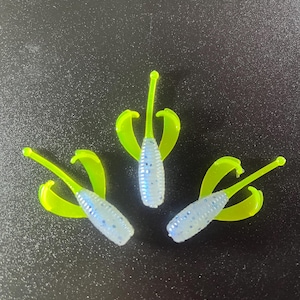 May include: Three blue and white soft plastic fishing lures with neon green tails.
