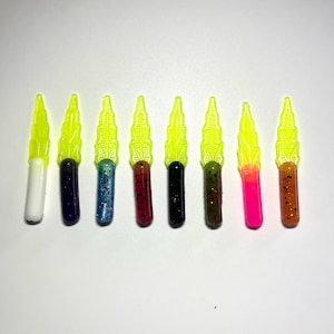 May include: Eight different colored plastic fishing lures with a yellow, leaf-shaped design. The lures are approximately 2 inches long.