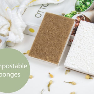 May include: Two compostable sponges, one brown and one white, on a white surface with small yellow flowers. The text "Compostable Sponges" is written in green on a light green circle.