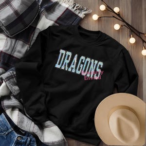 May include: A white ceramic mug with a black handle and the text "But First, Coffee" in a black, handwritten-style font. The mug is on a white surface.