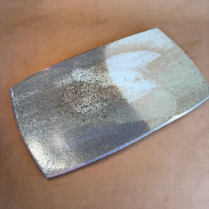 May include: Rectangular ceramic serving dish with a speckled, textured surface. The dish features a blend of colours, including gold, brown, and white, creating a unique and artistic appearance. The edges are slightly rounded, and the overall design is minimalist.