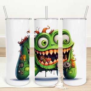 May include: White tumbler featuring a cartoon monster design. The green monster has large eyes, sharp teeth, and orange hair. The tumbler includes a silver straw and the text "Trick Yep".