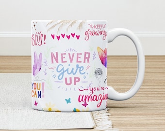 May include: White ceramic coffee mug with a colorful design featuring butterflies, hearts, and inspirational text. The text reads "Never give up", "You can", "Keep growing", and "You're amazing".