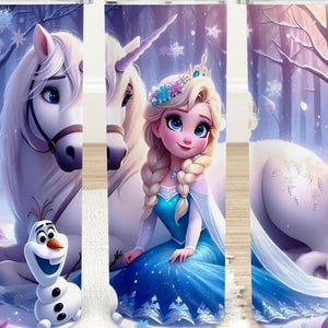 Puede incluir: Un vaso con una escena invernal con Elsa de Frozen, un unicornio blanco y Olaf el mu&ntilde;eco de nieve. El dise&ntilde;o incluye copos de nieve y un fondo de bosque nevado, con una combinaci&oacute;n de colores azul y morado.