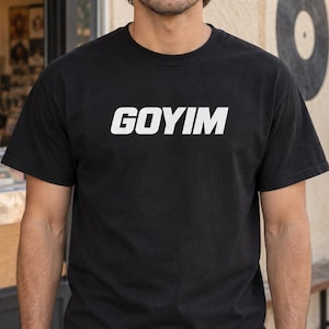 May include: A black short-sleeved t-shirt featuring the word GOYIM printed in bold white capital letters across the chest. The garment has a classic crew neckline and a straight hem, constructed from a solid black fabric with a standard fit.