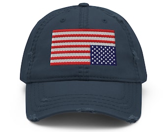 Könnte beinhalten: Eine abgenutzte Baseballkappe in Marineblau mit einem gestickten amerikanischen Flaggenmuster. Die Flagge ist verkehrt herum, mit den Sternen auf der linken Seite und den Streifen auf der rechten Seite.