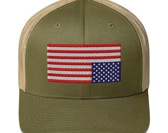 Könnte beinhalten: Eine grüne und braune Trucker-Kappe mit einer gestickten amerikanischen Flagge auf der Vorderseite. Die Flagge ist verkehrt herum.