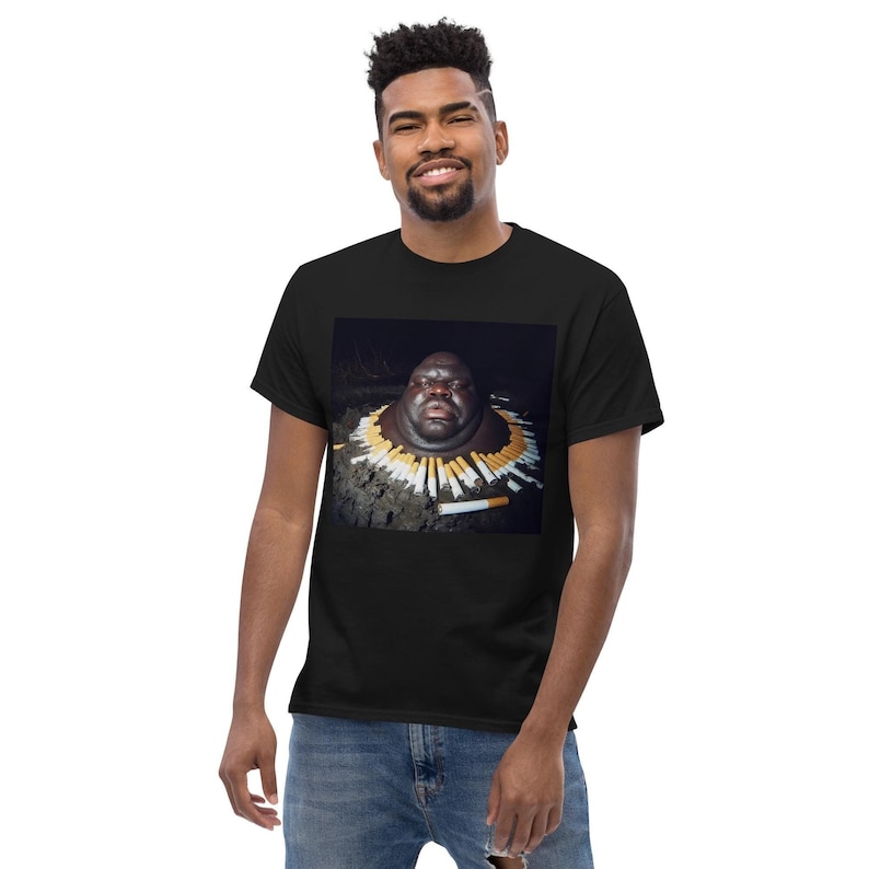 May include: A black t-shirt featuring a graphic print of a person's head surrounded by cigarettes.