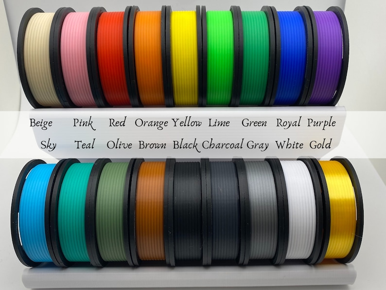 May include: A collection of 18 spools of filament for 3D printing in various colors, including beige, pink, red, orange, yellow, lime, green, royal blue, purple, sky blue, teal, olive, brown, black, charcoal gray, white, and gold.