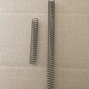 May include: Two metallic gray coil springs of different lengths are displayed against a neutral background. The longer spring is approximately 6 inches in length, while the shorter one is about 2 inches long. Both springs have a consistent coil design.