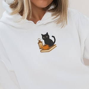 Black cat with book embroidered hoodie, halloween hoodie, black cat embroidered hoodie, cozy fall hoodie, cat hoodie, cat lover gift