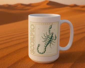 May include: White ceramic mug with a green scorpion illustration and the word "SCORPIO" in a gold font. The scorpion is surrounded by stars and the word "SCORPIO" is written vertically on the left side of the mug.